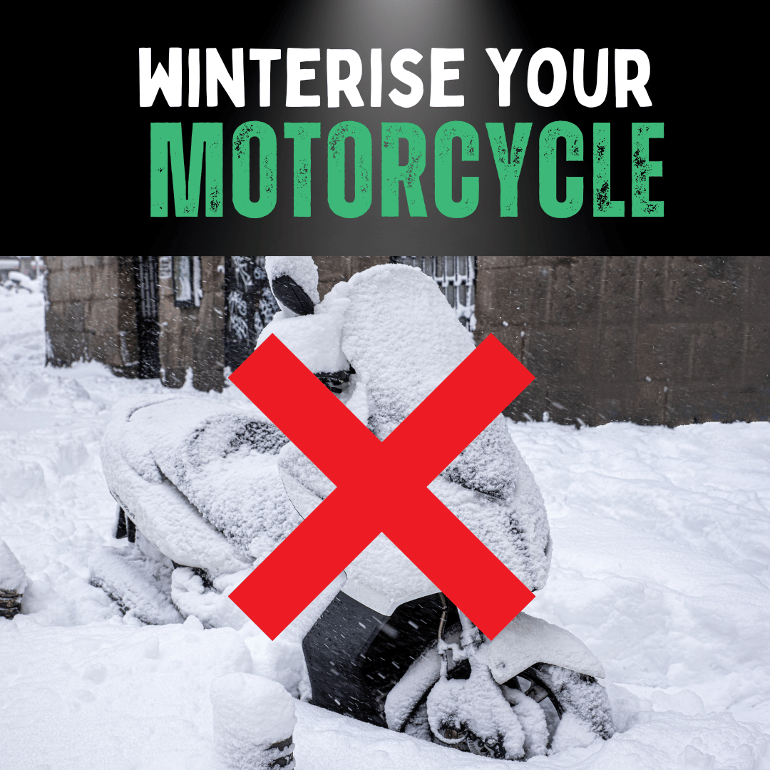 A motorcycle covered in snow with a red cross