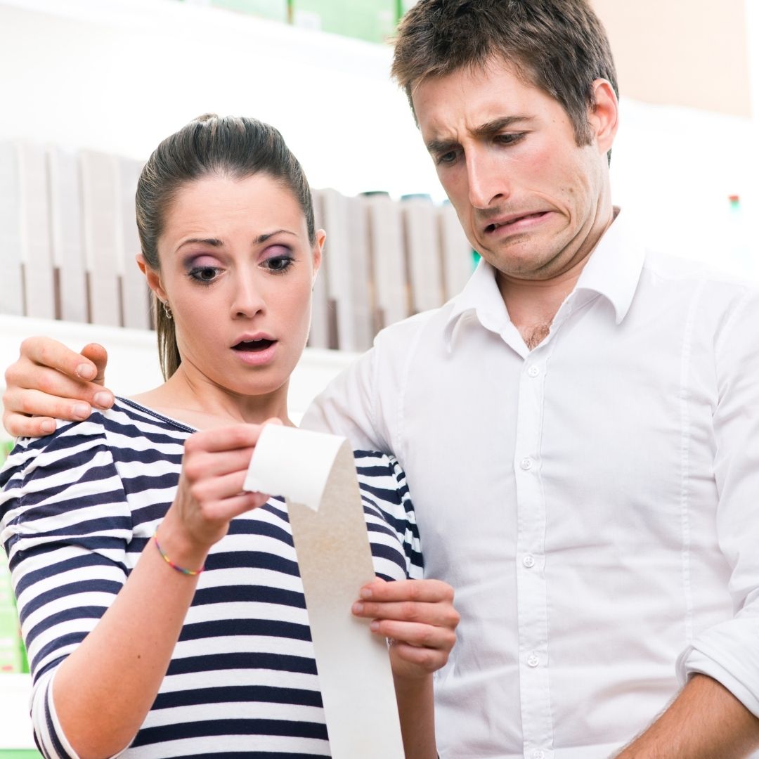 a couple looking shocked after they receive a bill