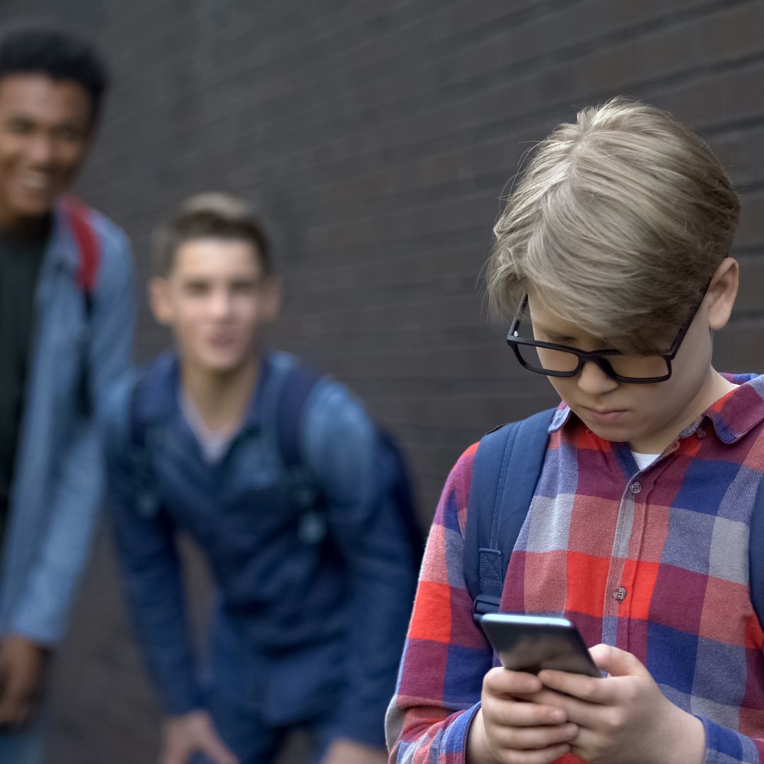 a kid dealing with Cyberbullying on their mobile