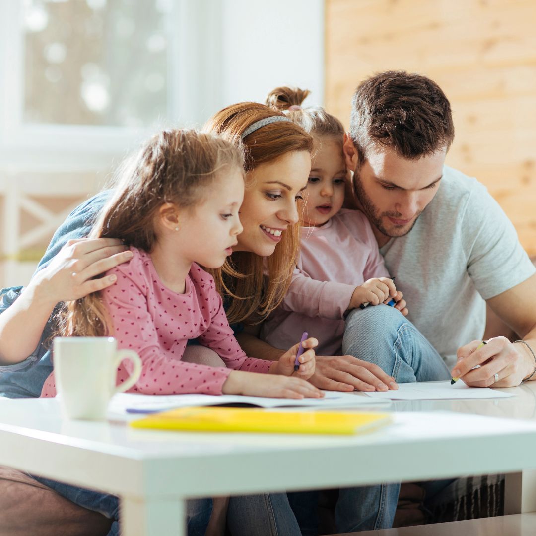 2 parents drawing with their two kids