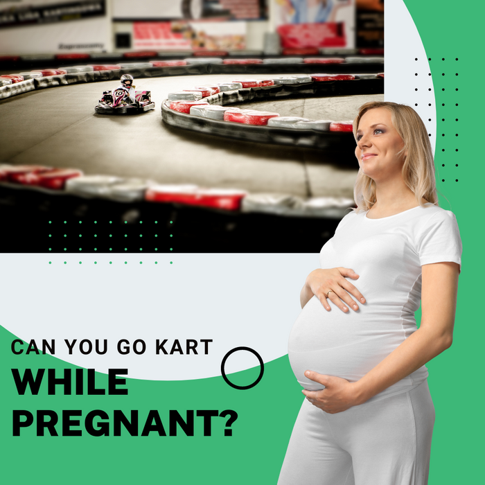 a pregnant woman holding her belly while looking at a go kart track