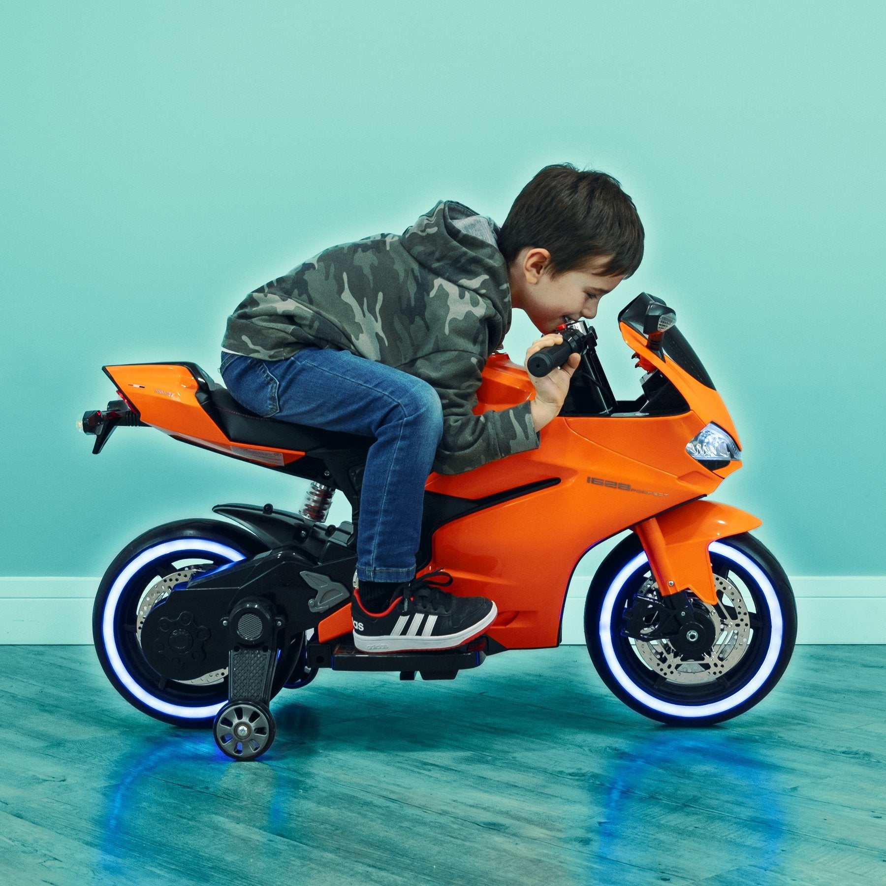 small boy sitting on Ducati syle ride on motorbike