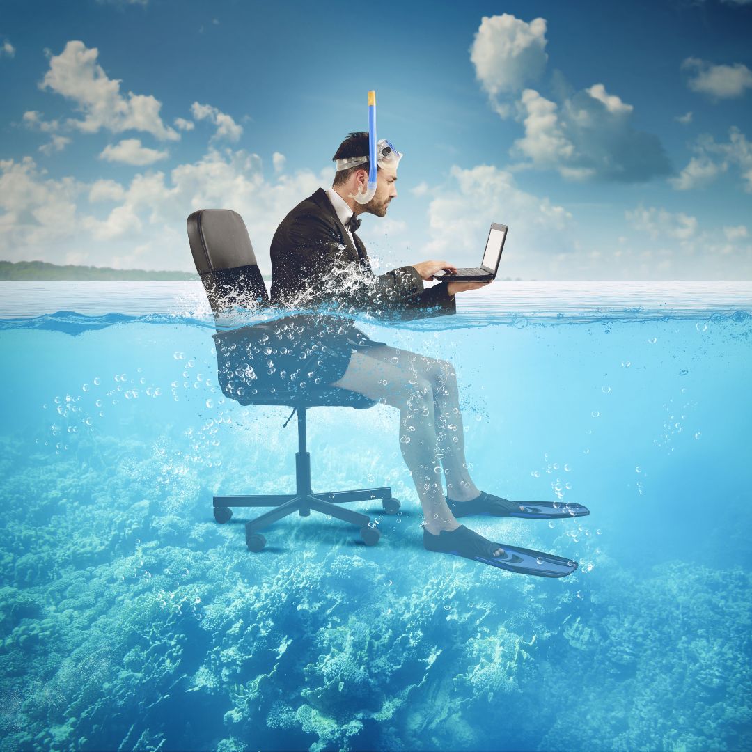 a man sitting on office chair on laptop in the sea