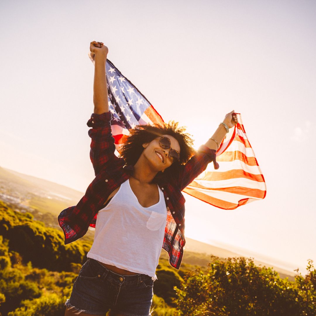 a mixed race woman holding an American flag