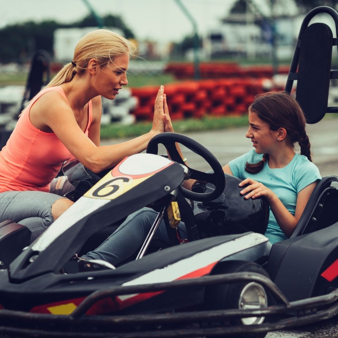 a mother putting her child in a go kart