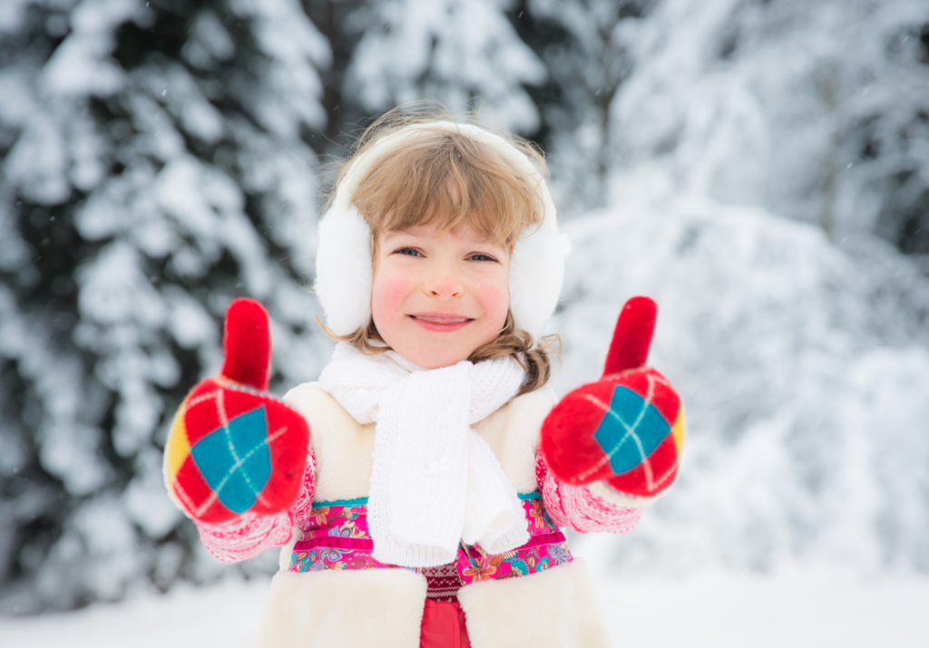 young girl in winter with her thumbs up