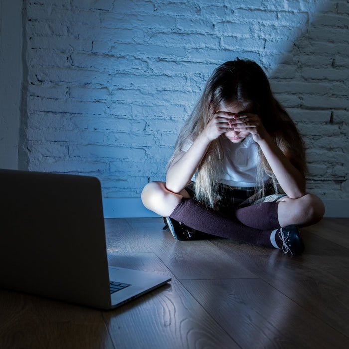 girl looking depressed as cyber bullying is happening on laptop