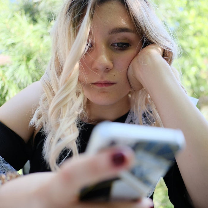 girl on phone looking depressed