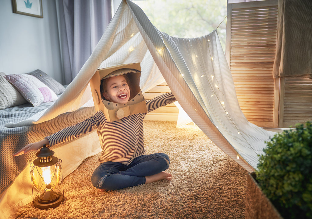 Kid playing under a sheet or tent