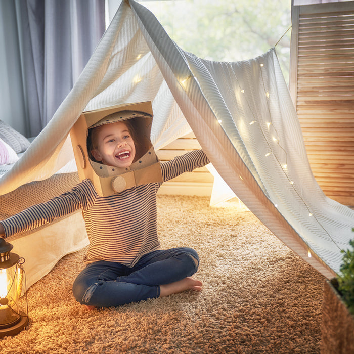 Kid playing under a sheet or tent