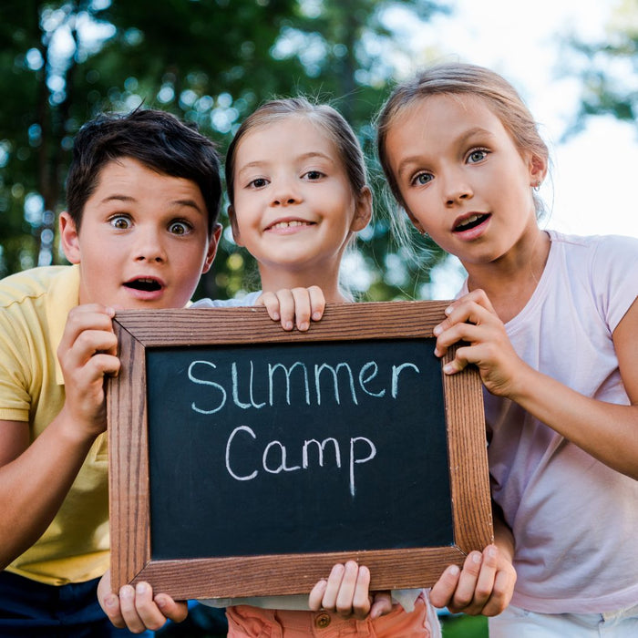 kids holding a sign that says summer camp
