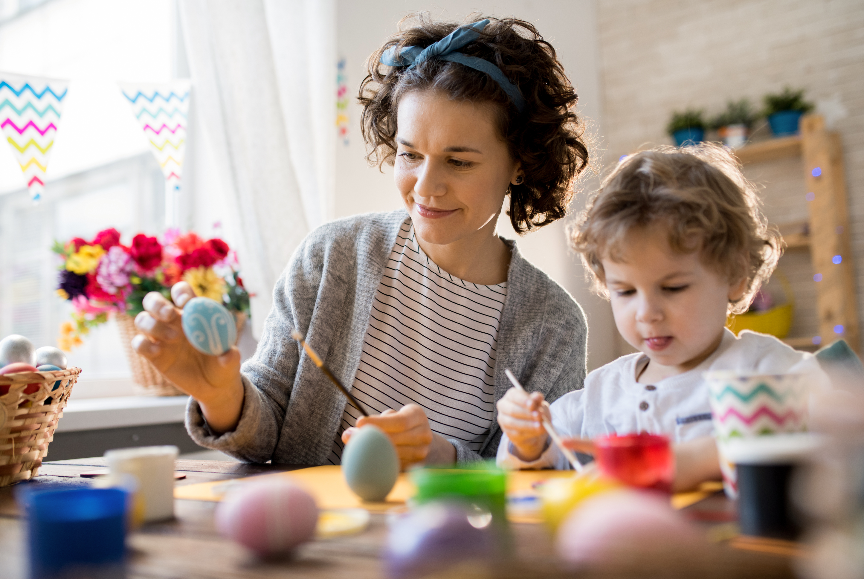 mother painting with her son at kitchen table