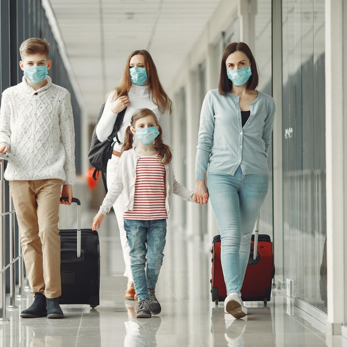 family in the airport wearing protective masks