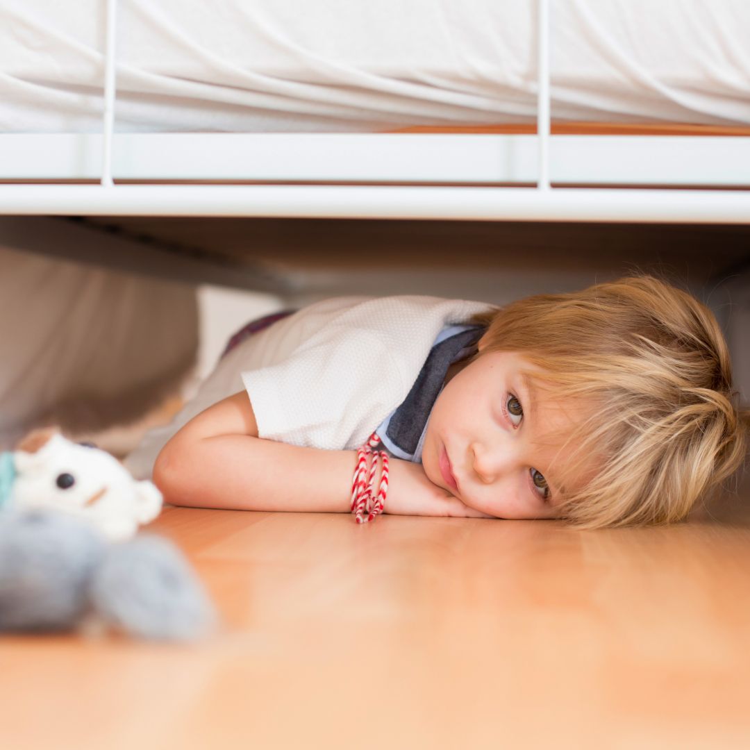 sad child under a bed