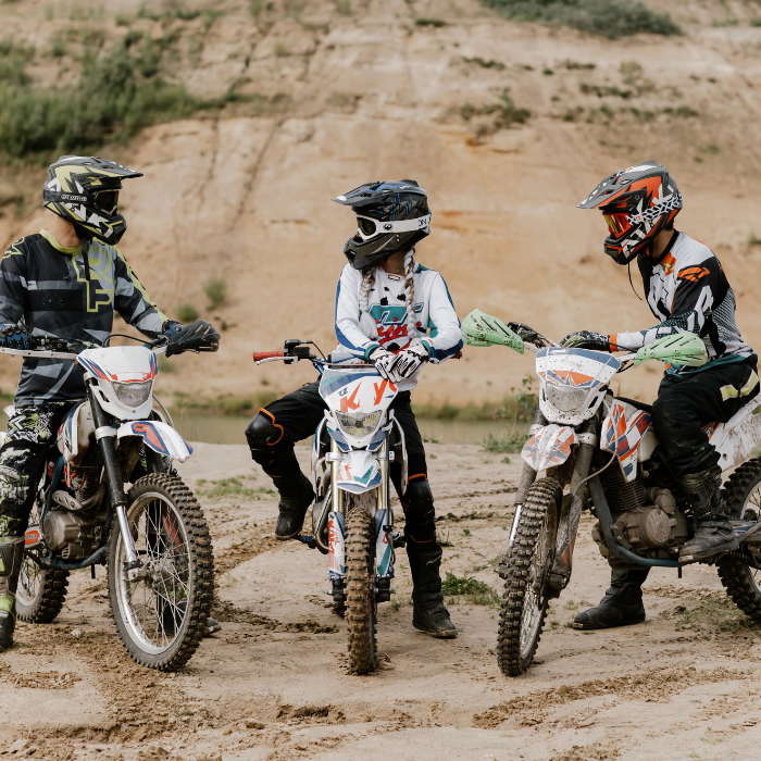 three kids on dirtbikes