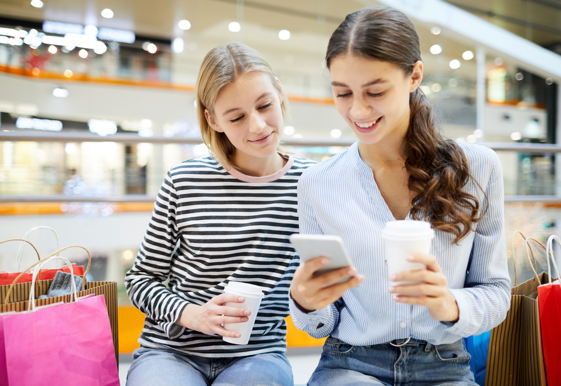 young girls in shop looking at mobile phone