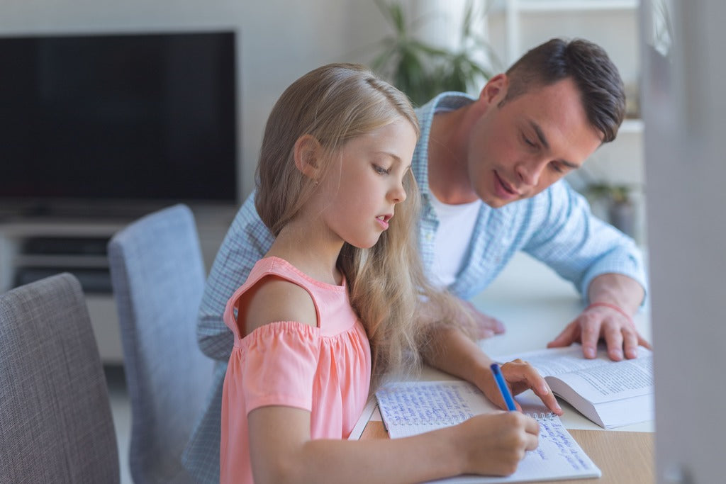 Father teaching his daughter at the table